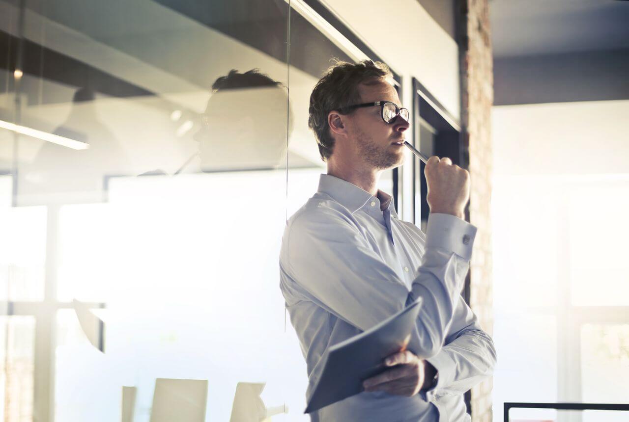 A man in a light colored shirt thinking through his decision