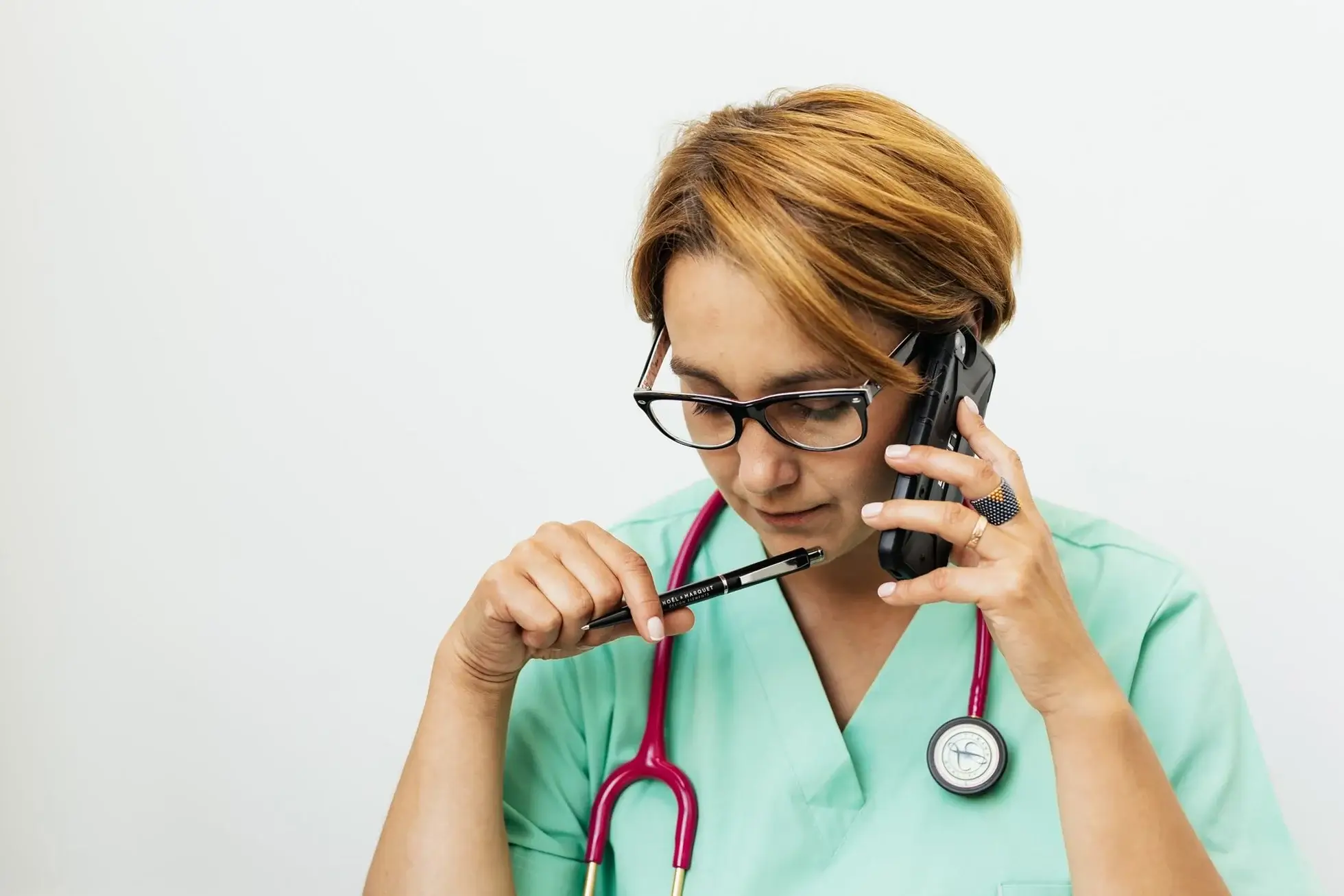 Female medical billier on the phone checking the best AI voice agents for healthcare RCM